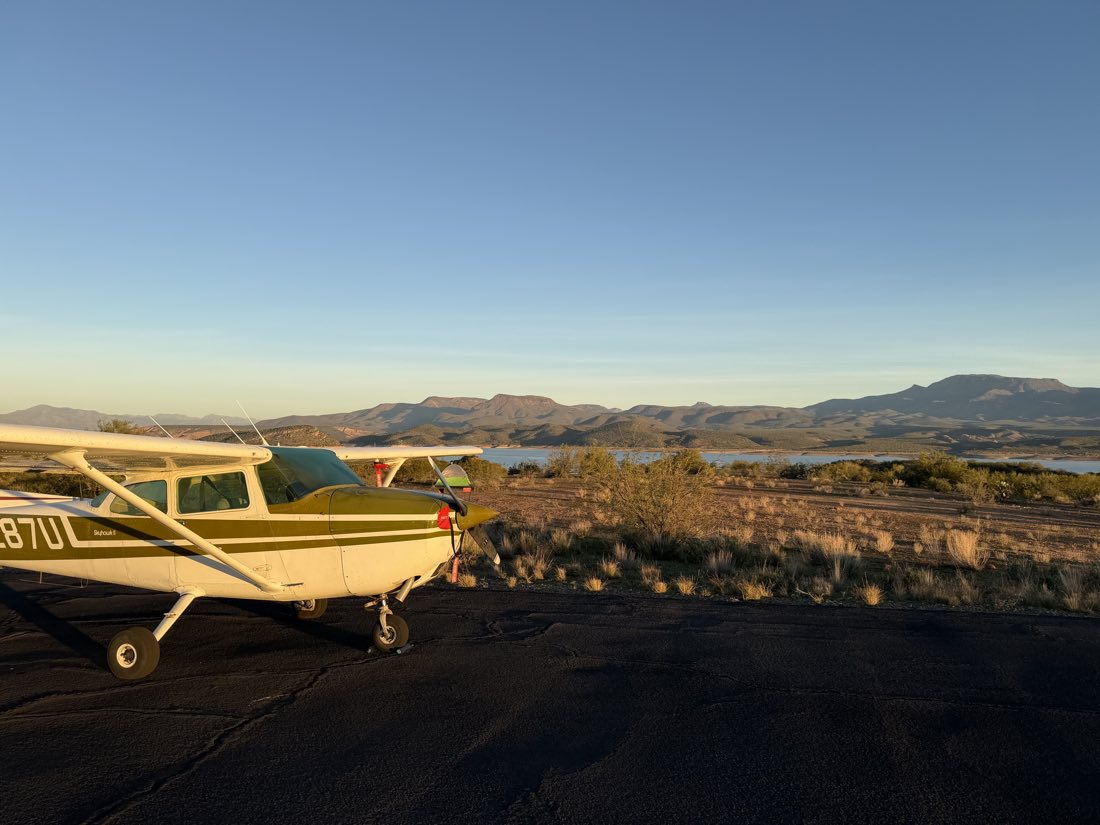 N1287U parked at a remote Arizona airstrip at golden hour with a tent beside it