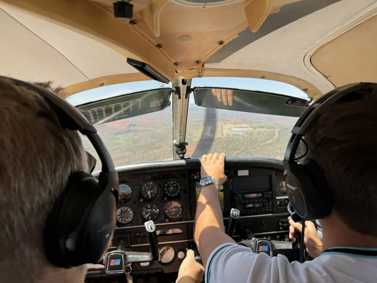 An instructor and student in the cockpit of a Cessna 172 on approach